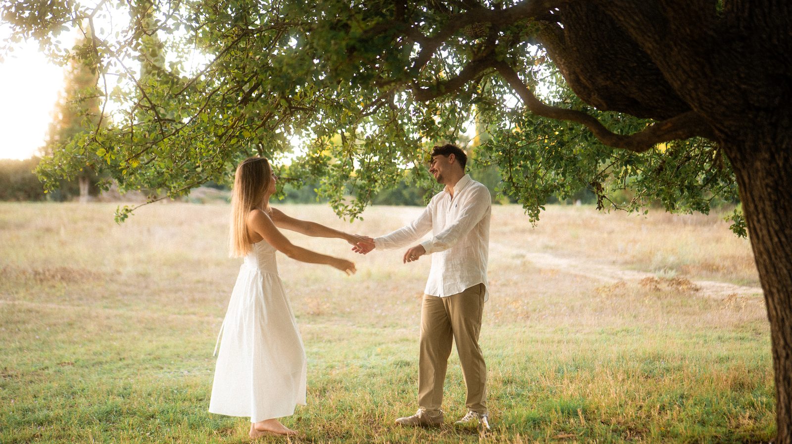 Manon et Benjamin se tenant les mains sous un grand arbre.