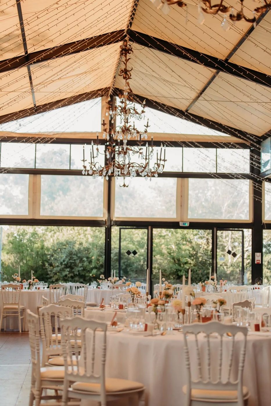 La salle de réception du château sous sa verrière, tables dressées.